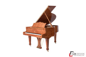 Ein Klavier aus rötlichem Holz auf komplett weißem Hintergrund