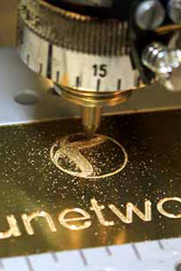 Graviernadel beim Gravieren eines goldenen Schilds für eunetwork